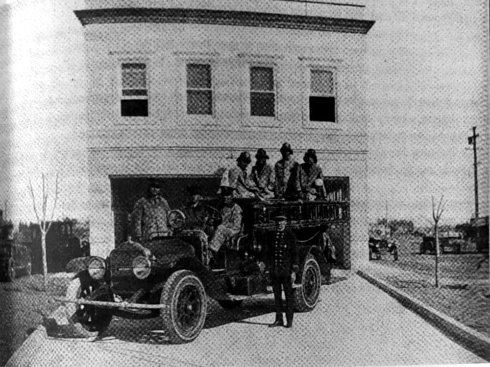 Cuerpo de bomberos frente a su estación en los años veinte